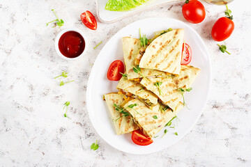 Wall Mural - Mexican Quesadilla wrap with chicken, corn and sweet pepper on white plate. Top view