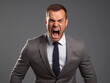 Young upset shouting young man or boss wearing classic suit attire isolated on light gray background.Angry boss 