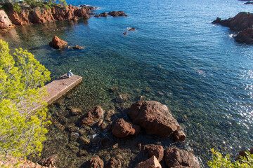 Wall Mural - Var, Côte d'Azur, bord de mer à Saint-Raphaël avec rochers et mer Méditerranée et ponton avec pêcheur