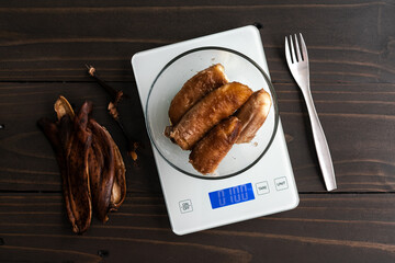 Wall Mural - Weighing Peeled Over-ripe Bananas on a Kitchen Scale: Glass bowl of very ripe bananas on a digital scale with peels and a fork on the side