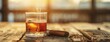 A glass filled with whiskey sits alongside a cigar on a rustic wooden table.