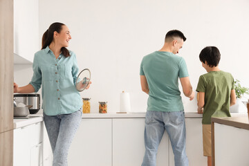 Canvas Print - Little boy with his parents washing dishes in kitchen