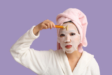 Canvas Print - Young Asian woman with facial sheet mask and massage tool after shower on lilac background, closeup