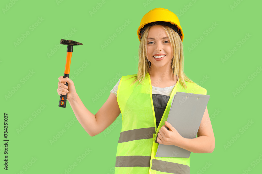 Female worker with hammer and clipboard on green background