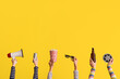 © Pixel-Shot - Many hands with bucket of popcorn, drinks and megaphone on yellow background