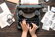 Woman typing on typewriter and criminal files on wooden background