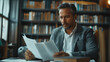 © akarawit - A businessman sitting and reading documents at the desk in modern office