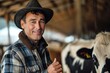 A rugged man in a plaid shirt and cowboy hat stands proudly with a smile, surrounded by cattle in the warm sun