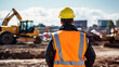 © AspctStyle - Back View of Construction Worker Overseeing Site with Heavy Machinery. Industrial Development Concept