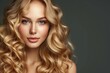 Beautiful model girl with blonde and shiny curly hair adorned by care and beauty hair products