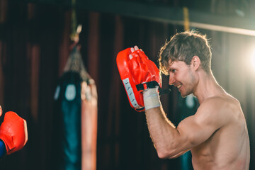 Wall Mural - Active, athletes and fit men kick boxing and doing sport training workout in a gym. Two male partners or MMA boxer and trainer practice sparring exercises for a healthy wellness lifestyle.