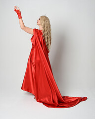Full length portrait of beautiful blonde model dressed as ancient mythological fantasy goddess in flowing red silk toga gown, crown.   Walking away from camera,  isolated on white studio background.