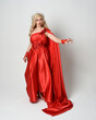 Full length portrait of  blonde model dressed as ancient mythological fantasy goddess in flowing red silk toga gown, crown. elegant dancing pose with flowing fabric isolated on white studio background