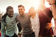 © Lomb - Group of multiracial men laughing together outdoors - Expression of joy and friendship among diverse friends. - Joyful Male Friends Bonding