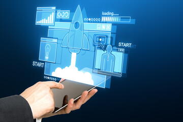 Wall Mural - close up of male hand using tablet with creative glowing rocket ship hologram on blue background. st