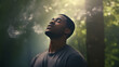 © Min - portrait of a black man standing in garden with eyes close and there is smoke behind him
