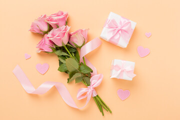 Wall Mural - Pink roses with hearts and gift box on color background, top view. Valentines day concept