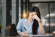 © SOMKID - Asian businesswoman are stressed and tired from work sitting at desk in the office, feeling sick at work, stress from work.