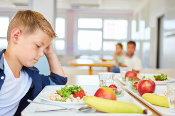 Wall Mural - Worried blond boy staring at food plate in school cafeteria