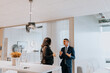 © Maskot - Smiling young businessman discussing with senior businesswoman in corridor