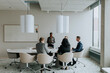 © Maskot - Mature businesswoman discussing strategy with colleagues in board room during meeting