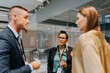 © Maskot - Businesswoman looking at businessman discussing strategy with colleague during seminar