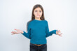 © Roquillo - Clueless beautiful kid girl wearing blue sweater shrugs shoulders with hesitation, faces doubtful situation, spreads palms, Hard decision