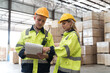 © amorn - Male and female warehouse worker working in lumber storage warehouse. Workers working in timber storage warehouse. Manufacturing and warehouse concept
