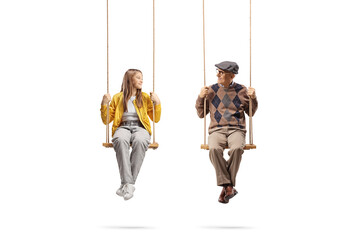 Canvas Print - Grandfather and granddaughter sitting on swings and looking at each other