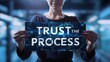 © Andrei - Motivational concept  woman holds  trust the process  sign for success against abstract background.