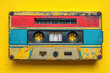 © ADDICTIVE STOCK - Vintage cassette tape on a yellow background Generative AI image