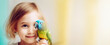 A girl's gentle smile reflects her delight with a colorful budgie. A pet at home