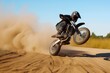 biker doing wheelie on dirt track, dust cloud behind