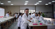 © Julio - A science professor in the laboratory with students in the background