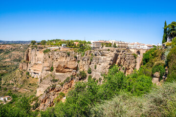 Wall Mural - Ronda, Spain. Aerial evening view of New Bridge over Guadalevin River in Ronda, Andalusia, Spain. View of the touristic city.