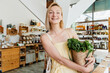 © nataliaderiabina - Smiling woman buying organic food and eco products in sustainable plastic free store. Happy female customer shopping at local grocery shop.