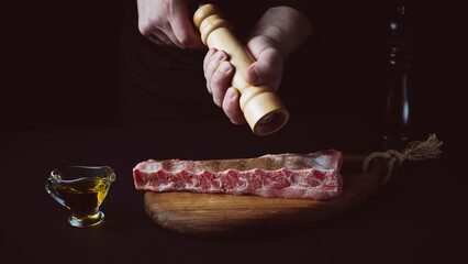 Wall Mural - the chef adds spices to the meat