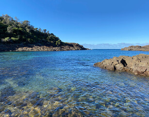 Wall Mural - Tropical island in the ocean. Rocky sea coast. View of ocean, mountains and shoreline. Landscape of a bay.