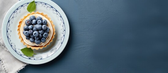 Poster - Top view on blueberry mini tart served on blue ceramic plate over gray textile napkin Top view Square image. Creative Banner. Copyspace image