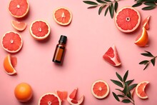 Flat Lay Composition With Grapefruit Essential Oil On Pink Background. Space For Text
