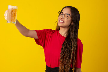 Wall Mural - woman with long curly hair wearing glasses and holding glass of cold beer