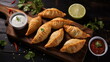 Golden Empanadas Served with Creamy Dip and Fresh Salsa on a Wooden Tray