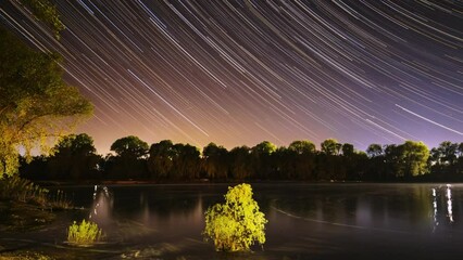 Wall Mural - Amazing Starry Effects. 4k Timelapse Night Sky Above River. Star Trails On Night Sky Background. Star Lines Move In Sky. Night Sky Turns Into Morning. From Dusk To Dawn. Dawn Is Coming. Time Lapse