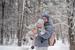 © KseniaJoyg - A young father and a littl child of 2 years old are laughing and having fun in a snowy winter forest on a walk