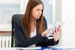 © Minerva Studio - Professional businesswoman using tablet at office desk