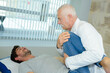 © auremar - physiotherapist bending knee of patient lying on treatment couch