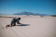 © Anna - An emaciated man crawls under the scorching sun on the sand in the desert.