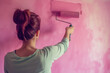 © kazakova0684 - woman paints the wall with paint roller in the room, pink color