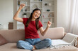 © Prostock-studio - Domestic Fun. Cheerful Young Asian Woman Listening Music In Wireless Headphones