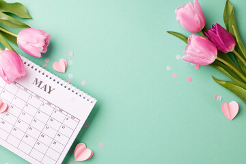 Wall Mural - May's blossoming gratitude: honoring motherhood. Top view shot of vibrant tulips surrounding a calendar on a refreshing turquoise background with space for loving messages